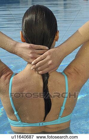 Stock Photo - Woman in the swimming pool - back view. Fotosearch