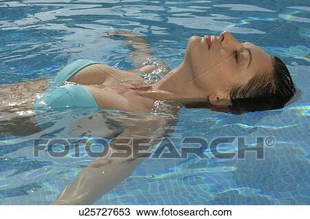 Stock Image - Woman is swimming backstroke. Fotosearch