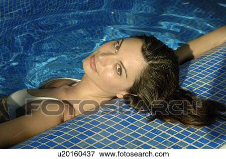 Stock Photo - Woman lying in a swimming pool. Fotosearch