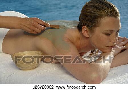 Stock Image - Woman with a fango poultice on her back. Fotosearch