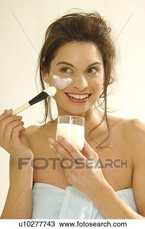 Stock Image - Woman with a yoghurt facial mask. Fotosearch