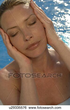 Woman with hands on her face View Large Photo Image Stock Photograph - Woman with hands on her face. Fotosearch