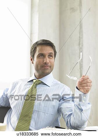 Business man is pointing with his glasses View Large Photo Image Stock Photography - Business man is pointing with his glasses. Fotosearch