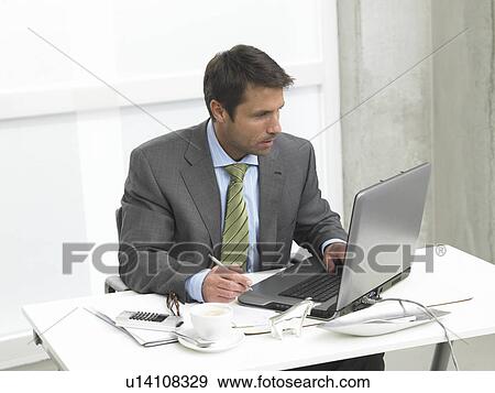 Stock Photo - Business man working with a notebook. Fotosearch