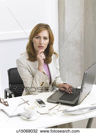 Business woman at her desk View Large Photo Image Stock Image - Business woman at her desk. Fotosearch