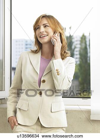 Business woman is phoning at the window View Large Photo Image Picture - Business woman is phoning at the window. Fotosearch