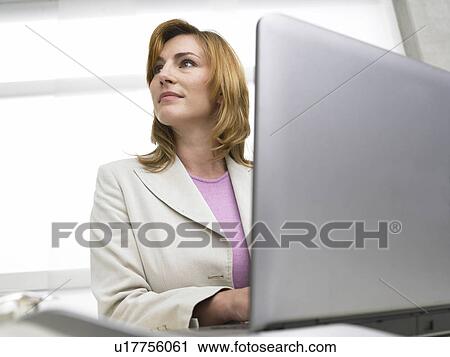 Stock Image - Business woman is working with her notebook. Fotosearch