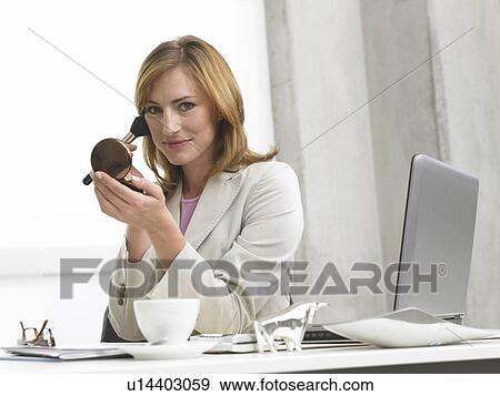 Stock Photo - Business woman with make up sitting at her desk. Fotosearch