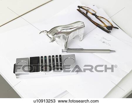 Stock Image - Glass bull, telephone, glasses and a pencil. Fotosearch