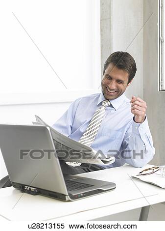 Laughing business man reading newspaper View Large Photo Image Stock Photography - Laughing business man reading newspaper. Fotosearch