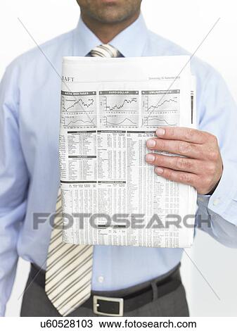 Stock Image - Man showing quotations in newspaper. Fotosearch