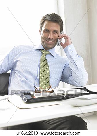 Stock Photo - Telephoning business man at his desk. Fotosearch