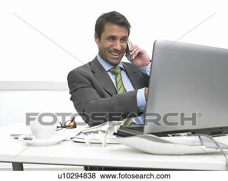 Stock Photo - Telephoning business man pointing on the computer screen. Fotosearch