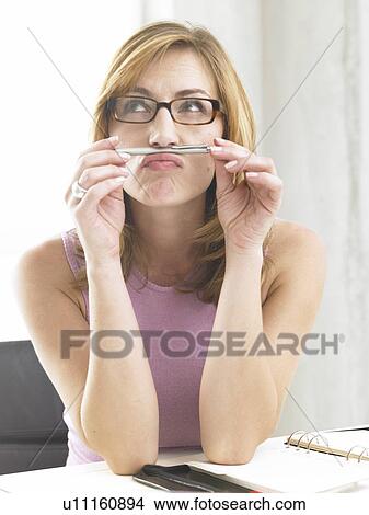Picture - Thoughtful business woman with a pen. Fotosearch