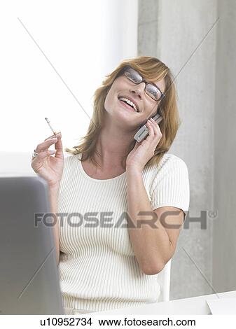 Picture - Woman is telephoning and smoking. Fotosearch