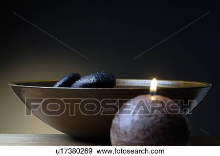 Bowl with black stones and a candle View Large Photo Image Stock Photo - Bowl with black stones and a candle. Fotosearch