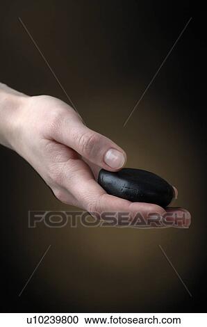 Hand is holding a black stone View Large Photo Image Stock Image - Hand is holding a black stone. Fotosearch