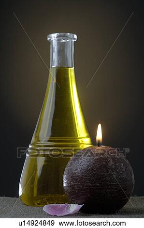 Stock Photo - Oil with a candle and a petal. Fotosearch