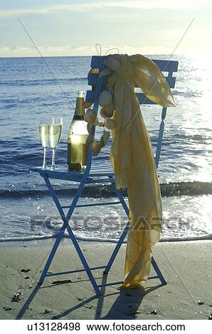 A bottle of sparkling wine on a chair at the beach View Large Photo Image Stock Photo - A bottle of sparkling wine on a chair at the beach. Fotosearch
