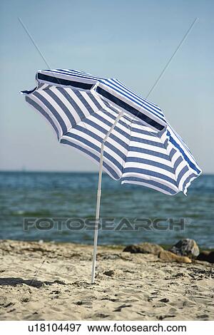 Stock Photo - Blue and white sunshade on the beach. Fotosearch