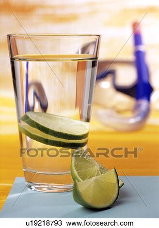 Stock Image - Glass of water with slices of lime. Fotosearch