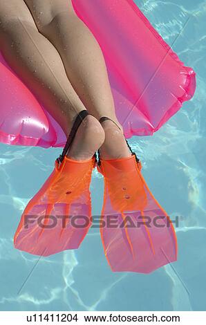 Picture - Legs with flippers on a air matress. Fotosearch