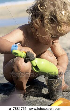 Little girl with a shovel on the beach, playing in the sand View Large Photo Image Stock Photography - Little girl with a shovel on the beach, playing in the sand. Fotosearch