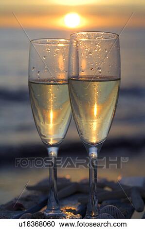 Stock Image - Two glasses of sparkling wine in the sunset at the sea. Fotosearch