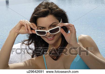 Stock Image - Woman on the sunlounger with sunglasses. Fotosearch