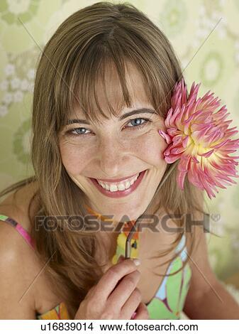 Picture - Woman with a chrysanthemum blossom. Fotosearch