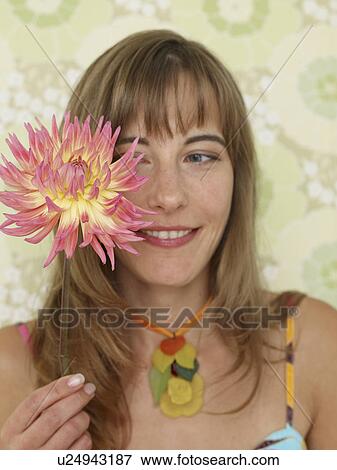 Stock Photo - Woman with a chrysanthemum blossom. Fotosearch
