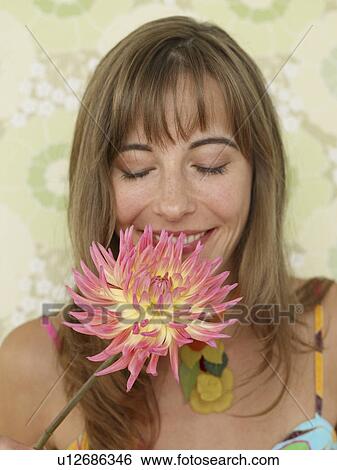 Stock Photograph - Woman with a chrysanthemum blossom. Fotosearch