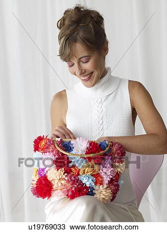 Stock Image - Woman with a flowery handbag. Fotosearch