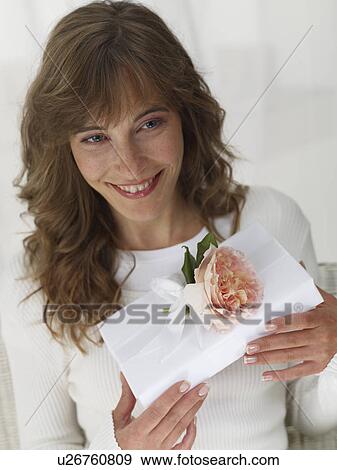 Woman with a white wrapped gift View Large Photo Image Stock Photo - Woman with a white wrapped gift. Fotosearch
