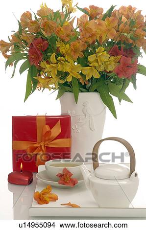 Picture - Arrangement of tea pot, a cup of tea, gift an bouquet. Fotosearch