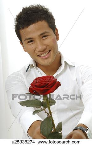 Picture - Asian man with a red rose. Fotosearch