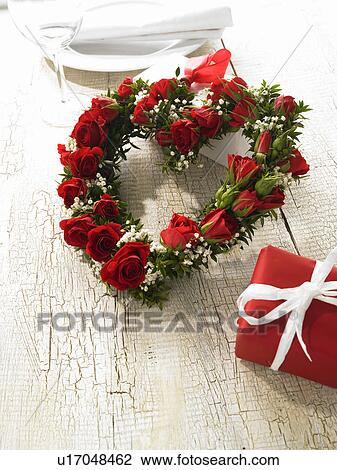Stock Image - Heart made of roses decorated with myrtle and baby`s breath. Fotosearch
