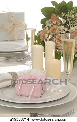 Place setting with gifts, candles, sparkling wine and a bouquet View Large Photo Image Picture - Place setting with gifts, candles, sparkling wine and a bouquet. Fotosearch