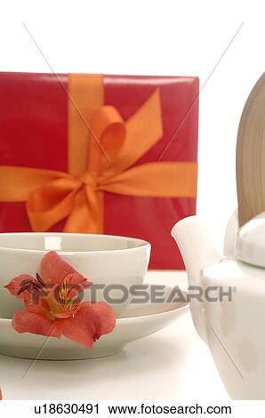 Stock Image - Tea pot, a cup of tea, gift and a petal. Fotosearch