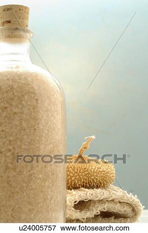 Stock Photo - A bottle of bath salts and other bathing utensils. Fotosearch