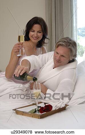 Stock Photo - Couple in bed with champagne. Fotosearch