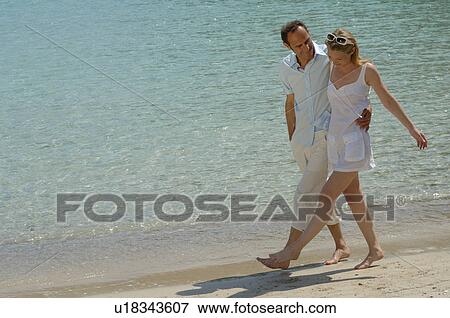Couple is walking on the beach View Large Photo Image Stock Photo - Couple is walking on the beach. Fotosearch
