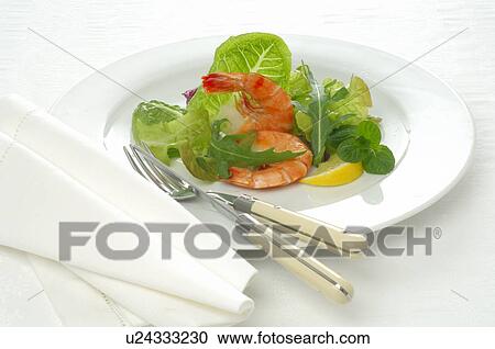 Stock Image - Dish of shrimps, lemon and salad. Fotosearch