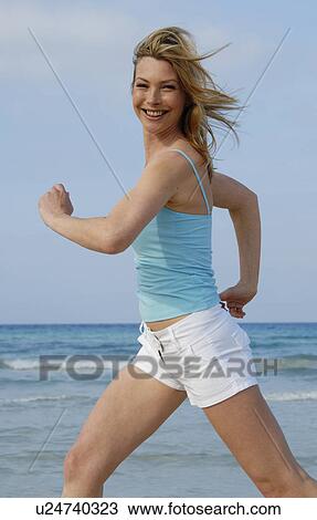 Stock Image - Jogging woman at the sea. Fotosearch