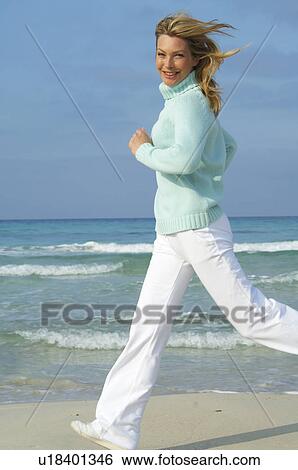 Stock Photograph - Running woman on the beach. Fotosearch
