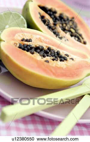 Stock Image - Sliced pawpaw tree fruit and limes. Fotosearch