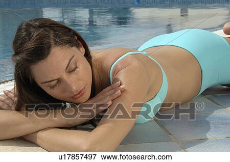 Stock Photo - Woman at the swimming pool in a turquoise bikini. Fotosearch