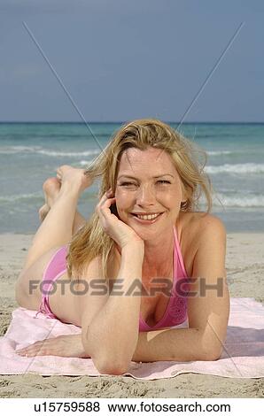Stock Photo - Woman is lying on the beach. Fotosearch