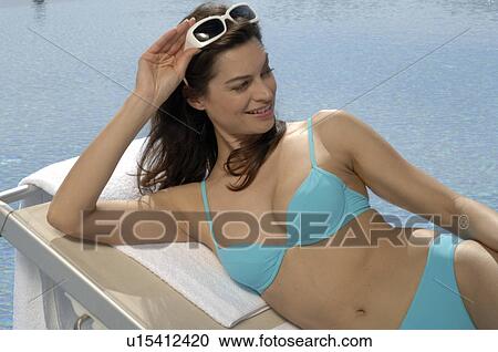 Woman on the sunlounger with sunglasses View Large Photo Image Stock Image - Woman on the sunlounger with sunglasses. Fotosearch
