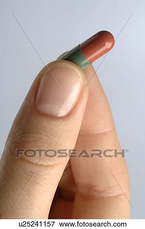 Stock Photo - A hand is holding a tablet. Fotosearch